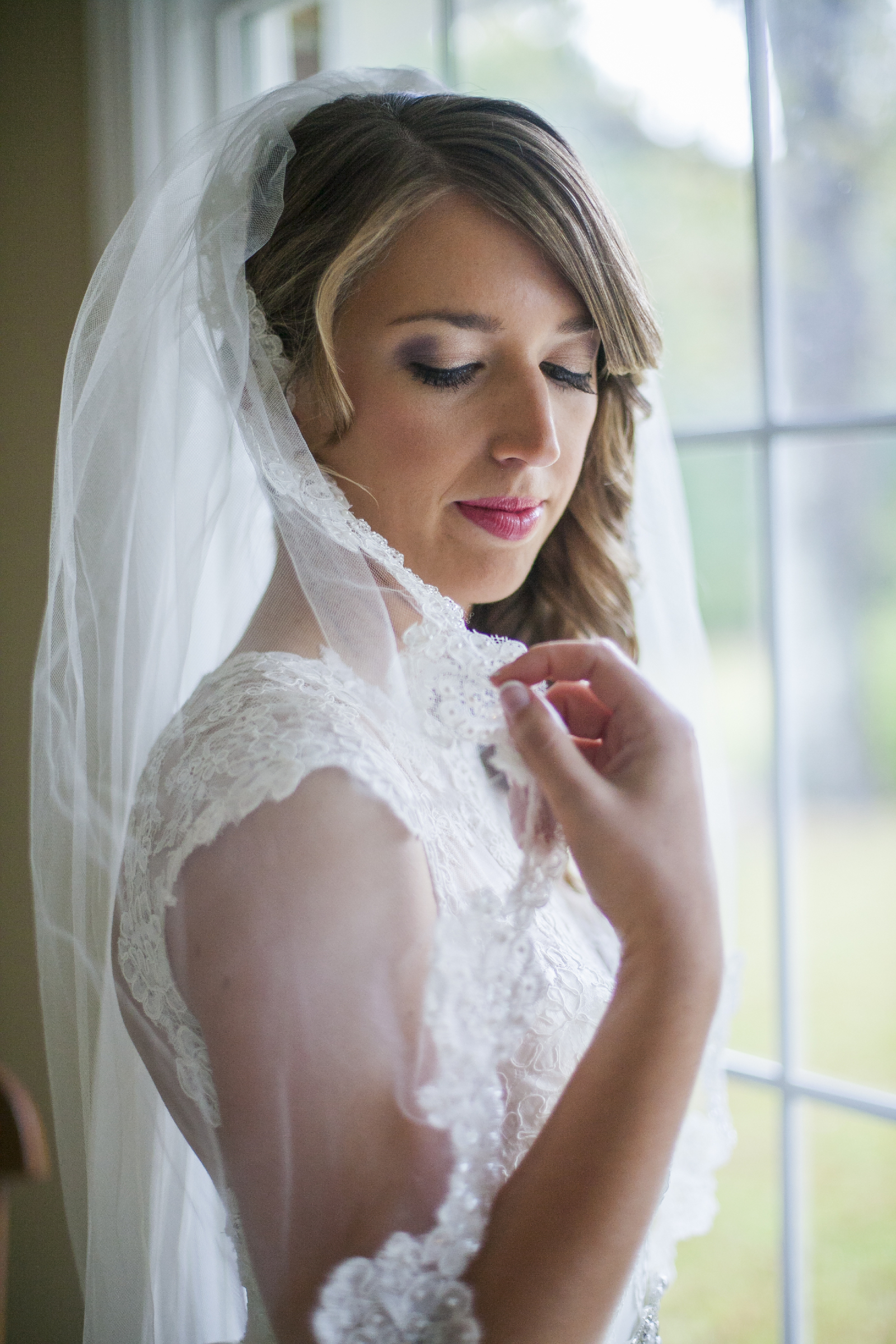 a bride inspects her spanish lace veil