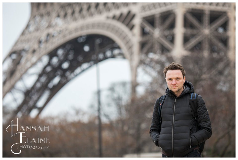 john poses in front of the eiffel tower