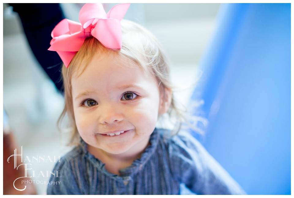 little girl with pink bow plays at her friend's first birthday party