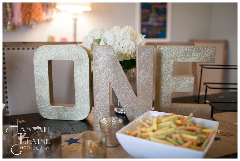gold sparkly letters spell one for birthday party decor