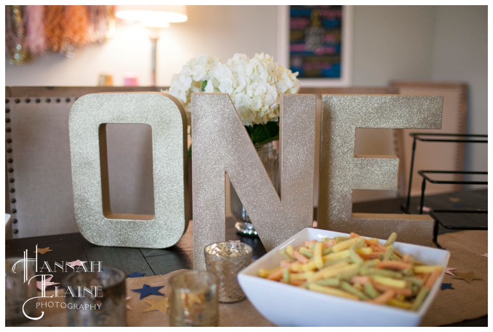 gold sparkly letters spell one for birthday party decor