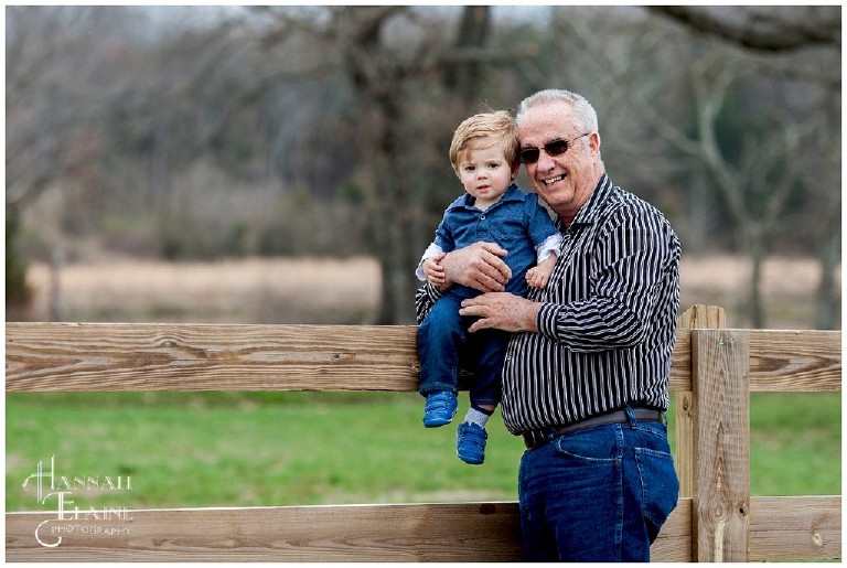 grandpa sits grandson on a wooden fence on a lebanon farm