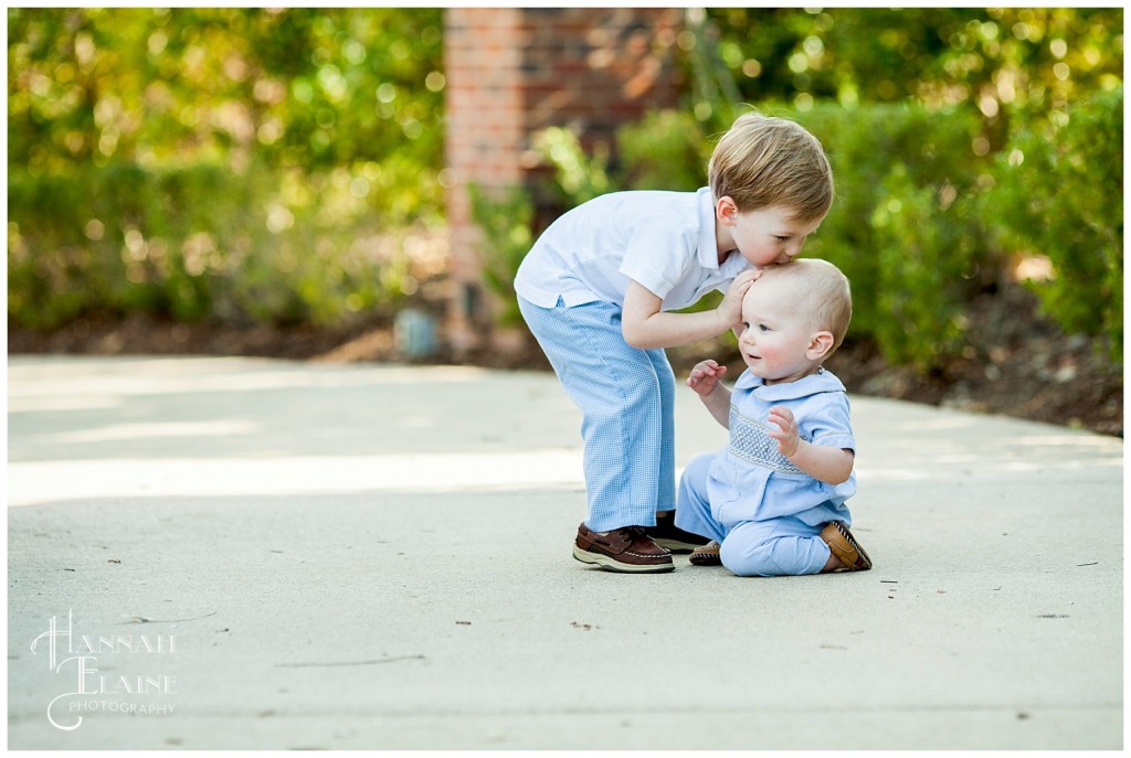 big brother kisses his little brother on the head