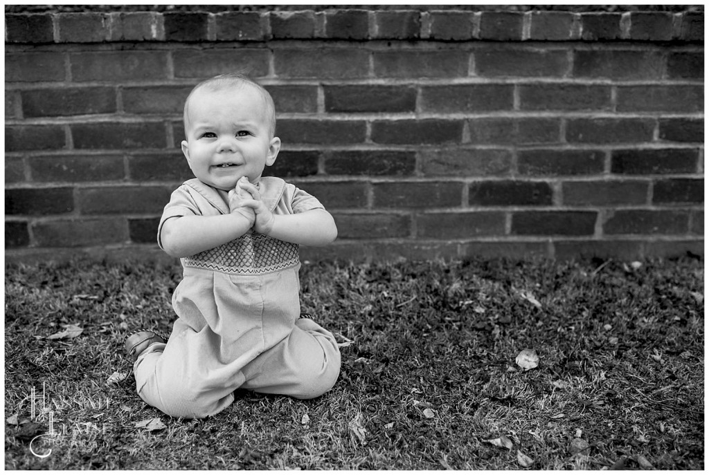 henry claps in front of a brick wall