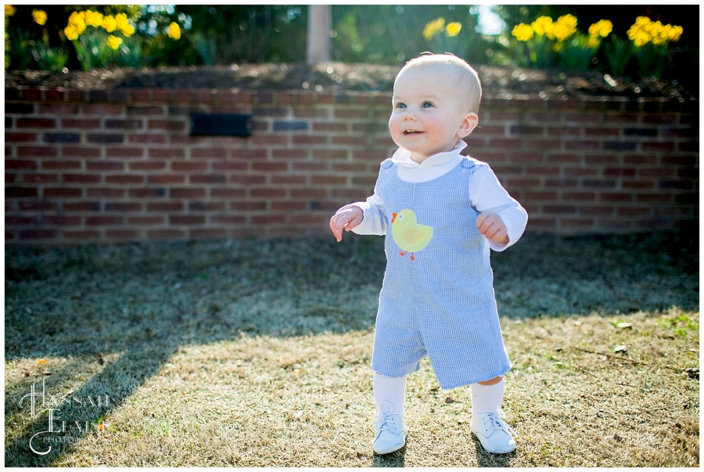 henry practices standing up all by himself in a ducky jumper