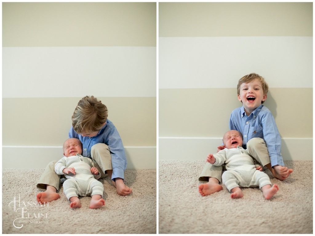 a painted striped wall behind ashton holding baby brother anders