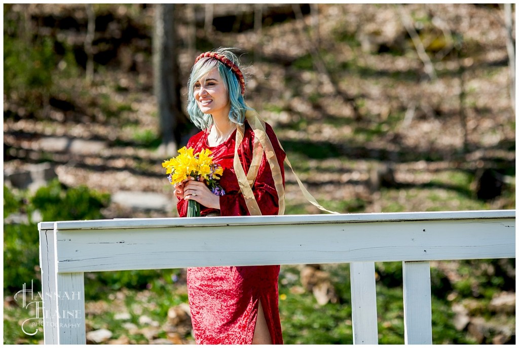 blue hair and red dress and yellow daffodils and white bridge