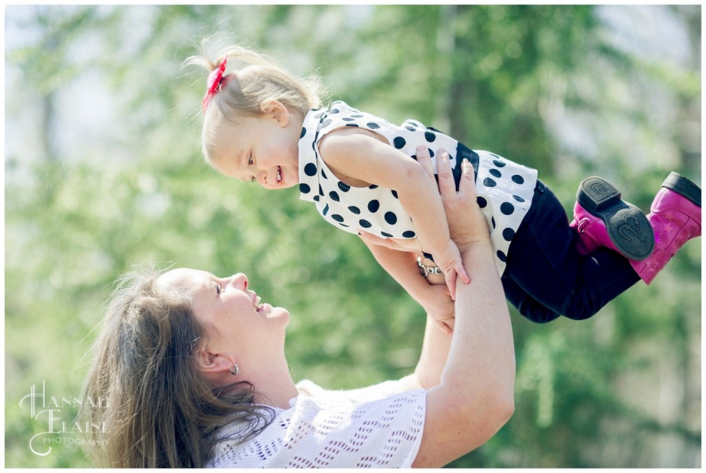 mom throws baby girl up to get a giggle