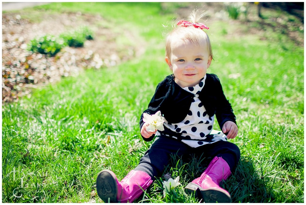 girl in bright pink boots holds a daffodil