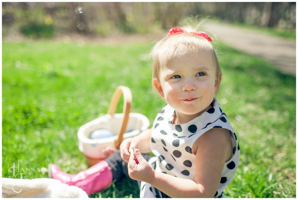 small girl partakes in the spoils from her easter egg hunt