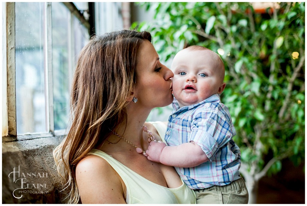 momma kisses her son by factory glass window