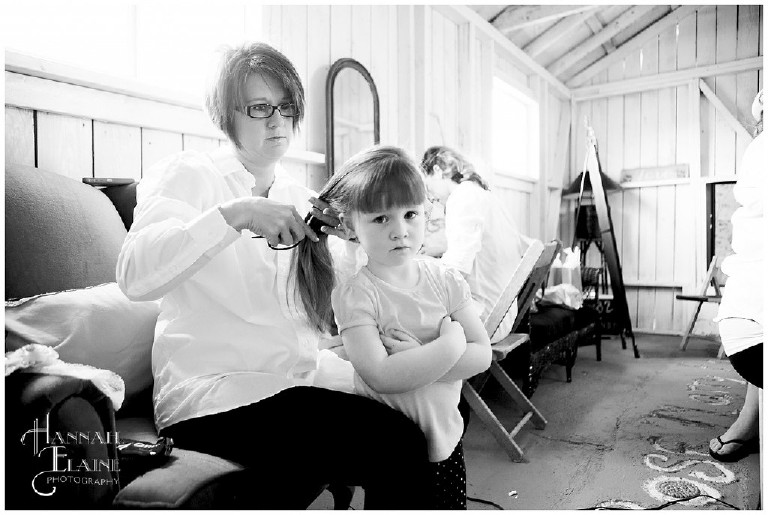 young flower girl gets her hair done before the wedding