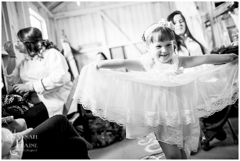 flower girl plays with her skirt in the bridal suite