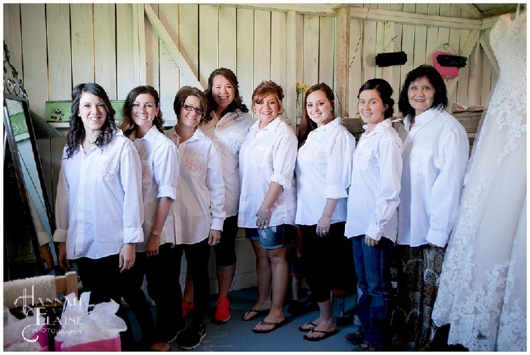 bridesmaids and bride stand together in matching monogrammed shirt