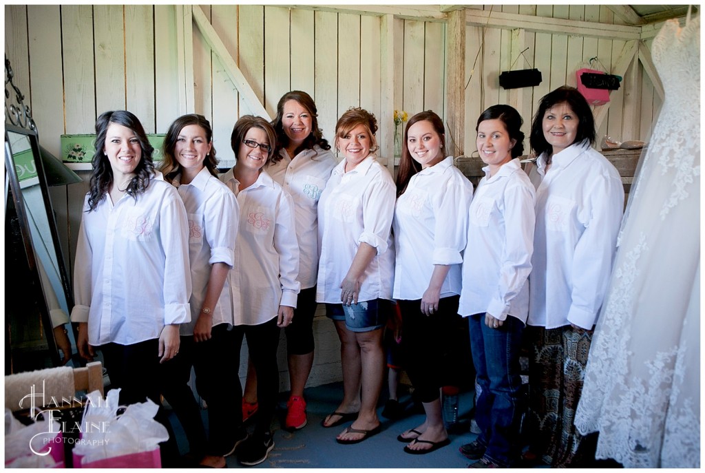 bridesmaids and bride stand together in matching monogrammed shirt