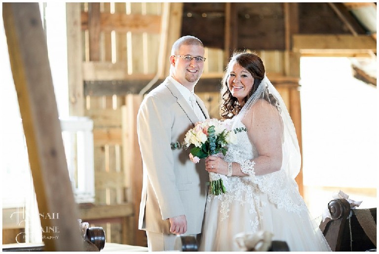 bride and groom stand in the aisle of their barn loft ceremony