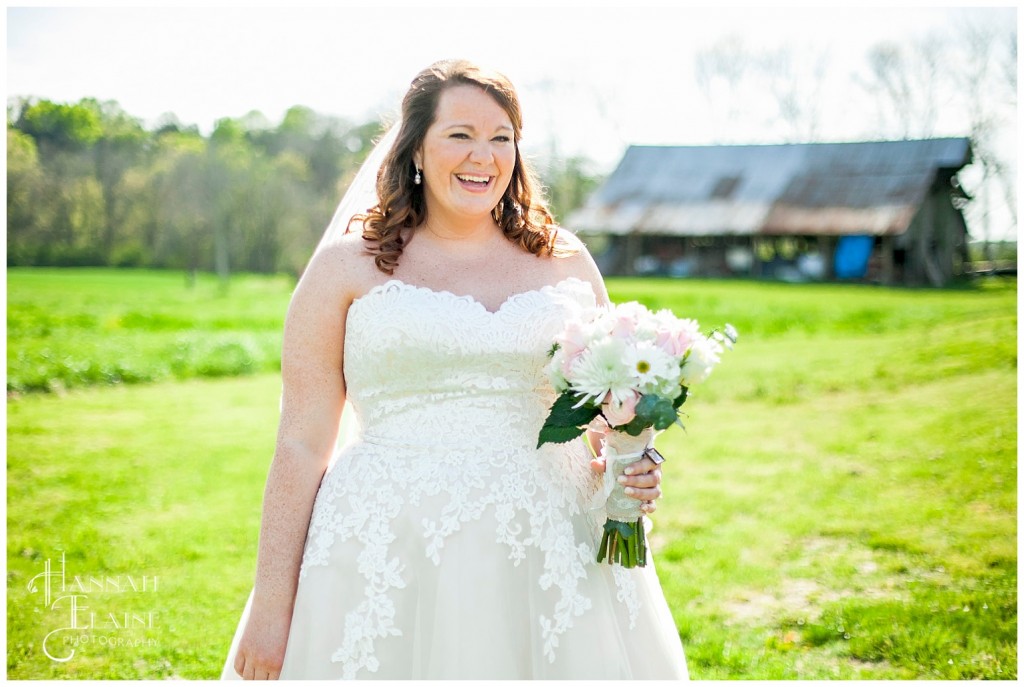 a girl in a lace bridal gown in a field