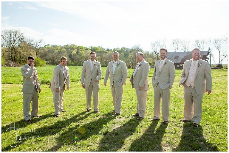 matt and his groomsmen stand in their tan suits and pink ties