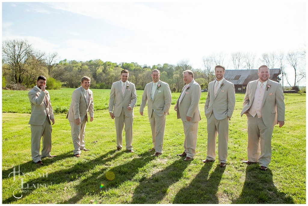 matt and his groomsmen stand in their tan suits and pink ties