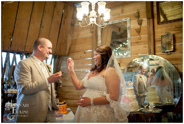 feeding each other the cake in the rustic barn