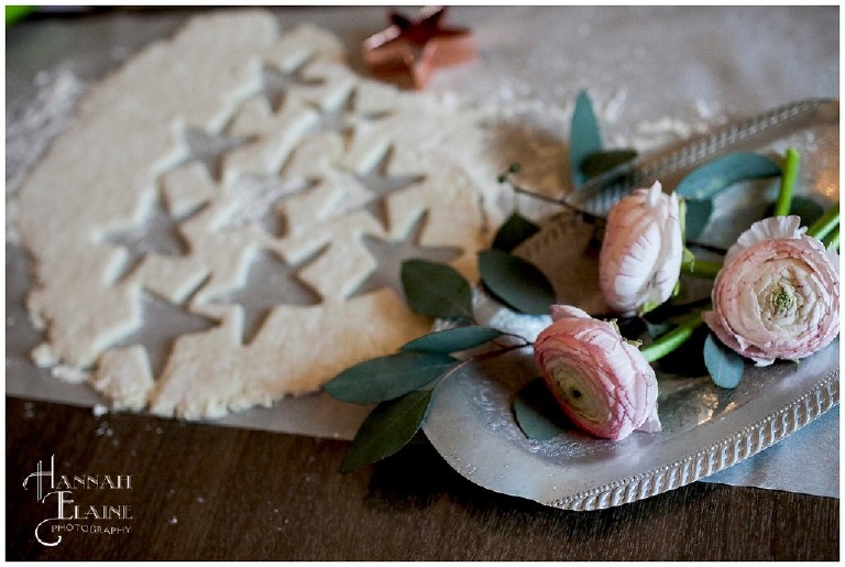 pink ranunculus and stars cut out of biscuit dough with copper cutter