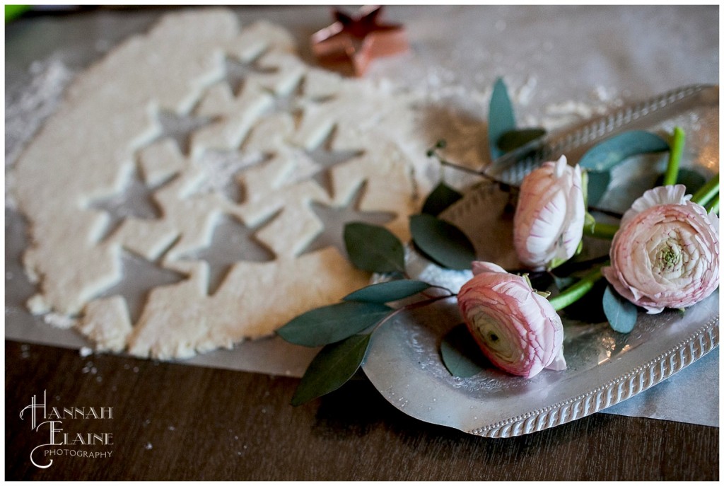 pink ranunculus and stars cut out of biscuit dough with copper cutter