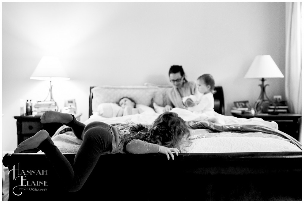 little girl crawls out of mom and dad's bed