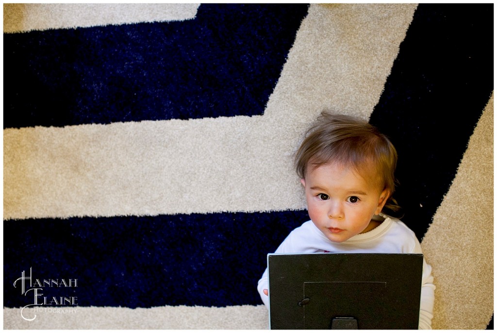 baby girl gets her diaper changed on a blue chevron rug