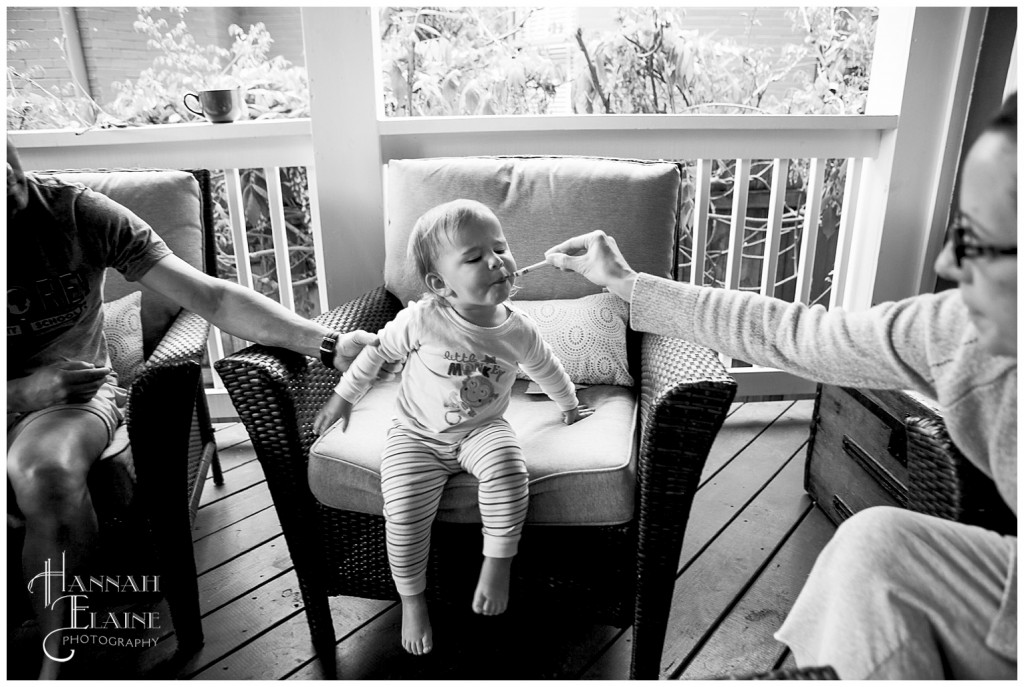 mom helps daughter eat her eggs at breakfast