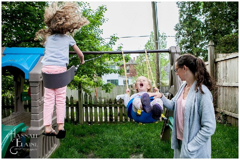 sisters swing together in the back yard in east nashville