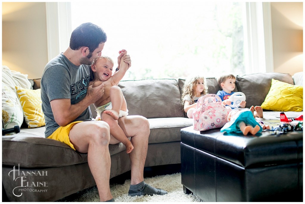 dad tickles baby while older siblings play mario kart wii