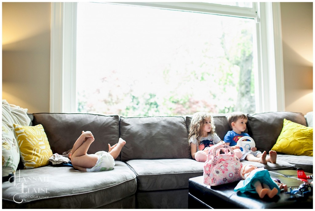 older kids play the nintendo wii while the baby rolls around