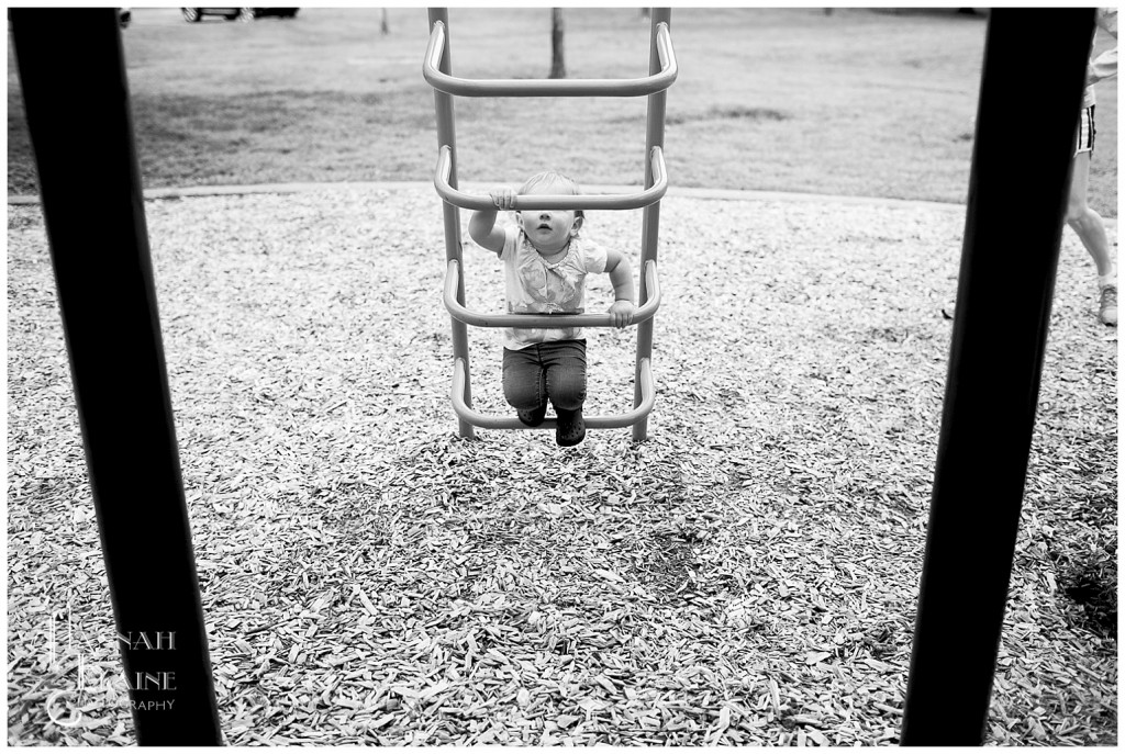 toddler tries to climb the playground ladder