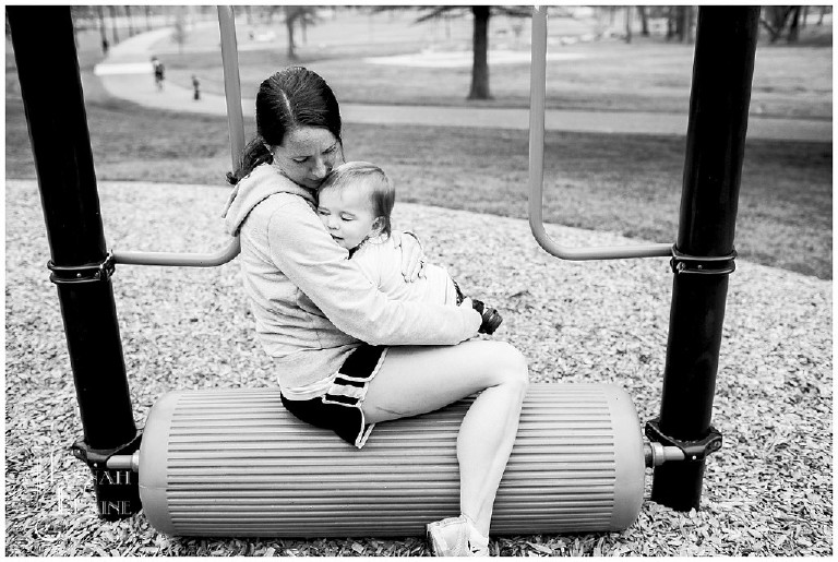 mom comforts baby after she bumps her head at the park