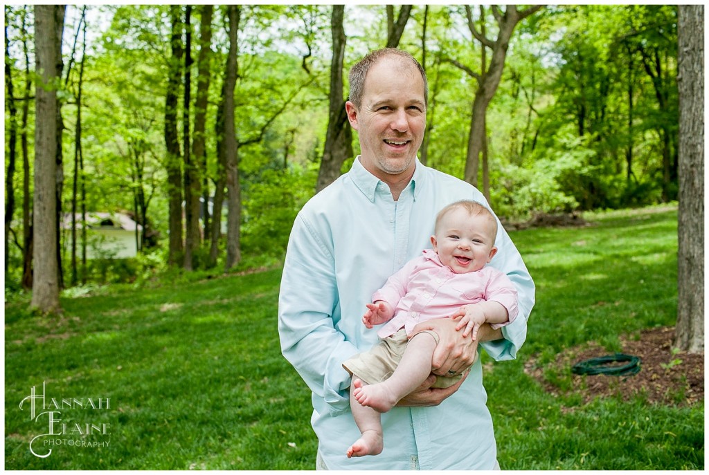 dad holds his 5 month old son for a family portrait