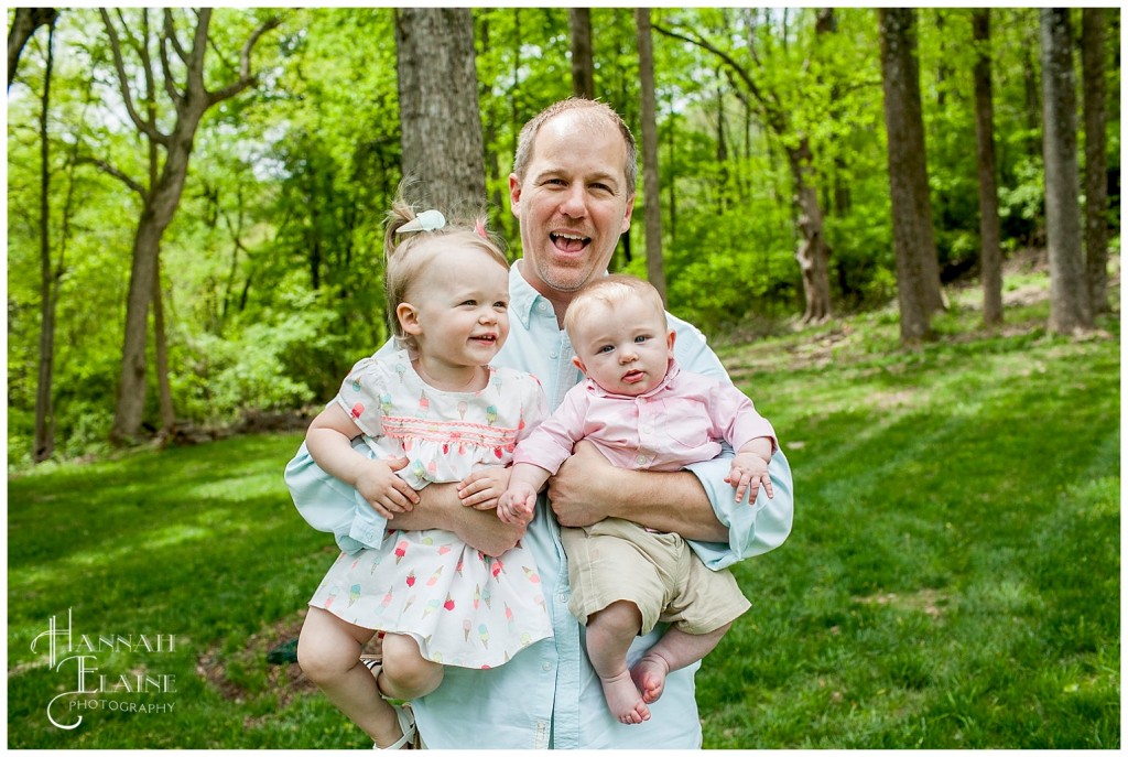 dad holds his wiggly kids