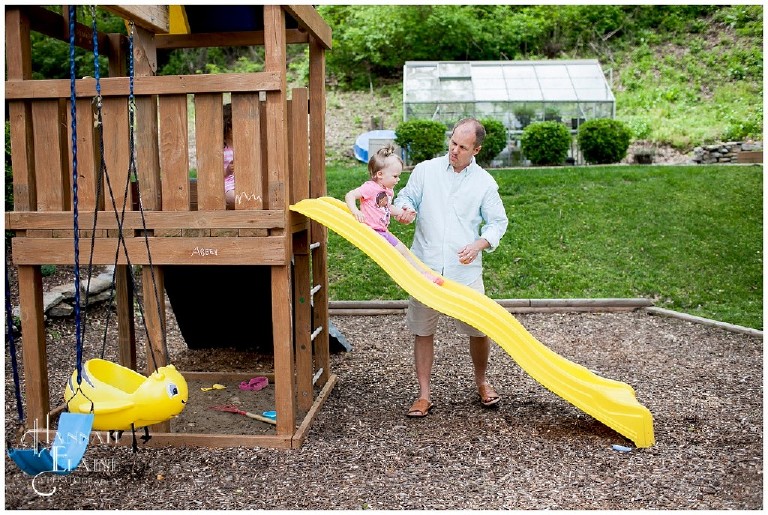 girl slides down her yellow slide with help from dad
