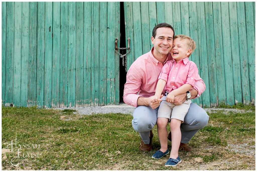 the deese boys in matching outfits hold hands in front of rustic green barn door