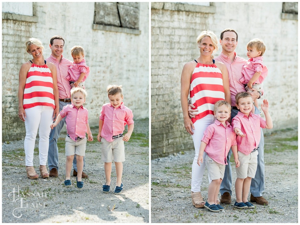 boys jumping for family photos in front of rustic stone barn wall