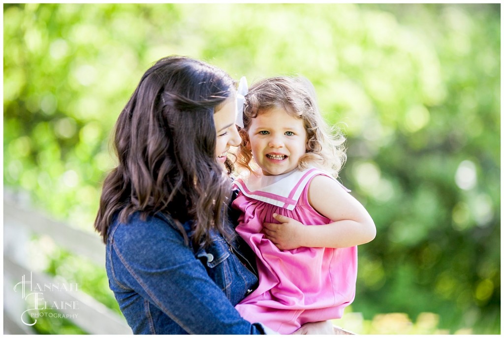 mom holds her daughter and whispers a secret