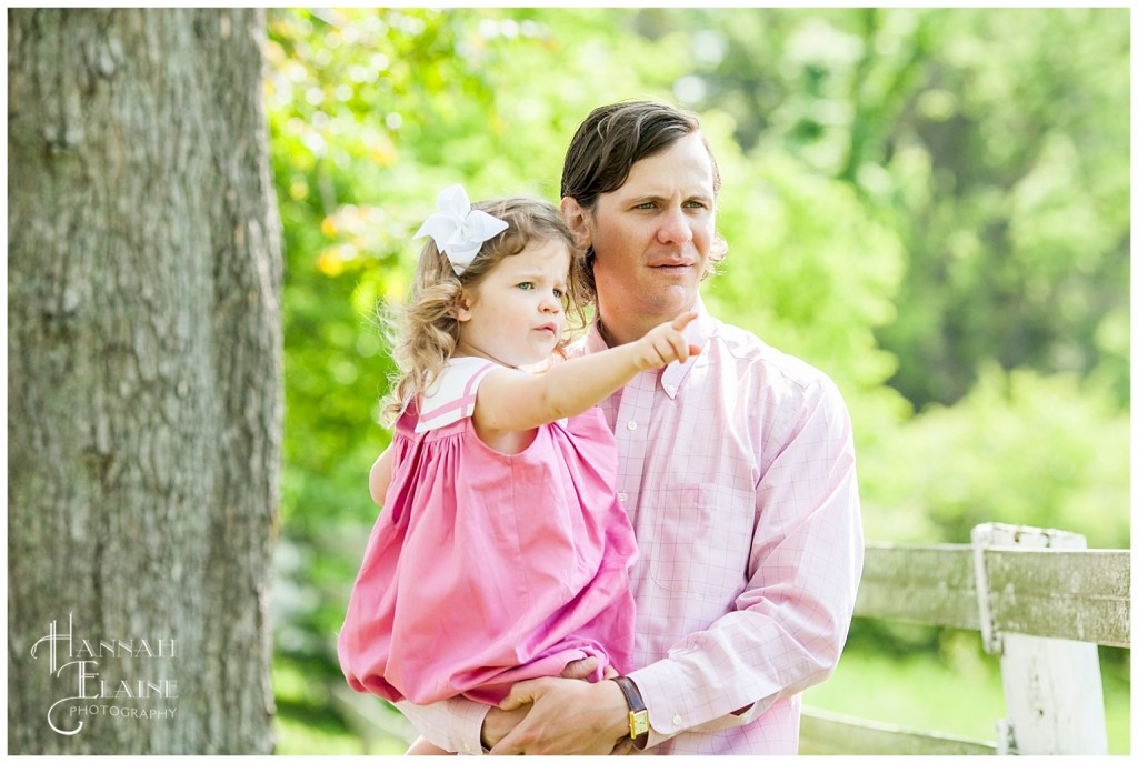 girl in daddy's arms counts all the horses in the field