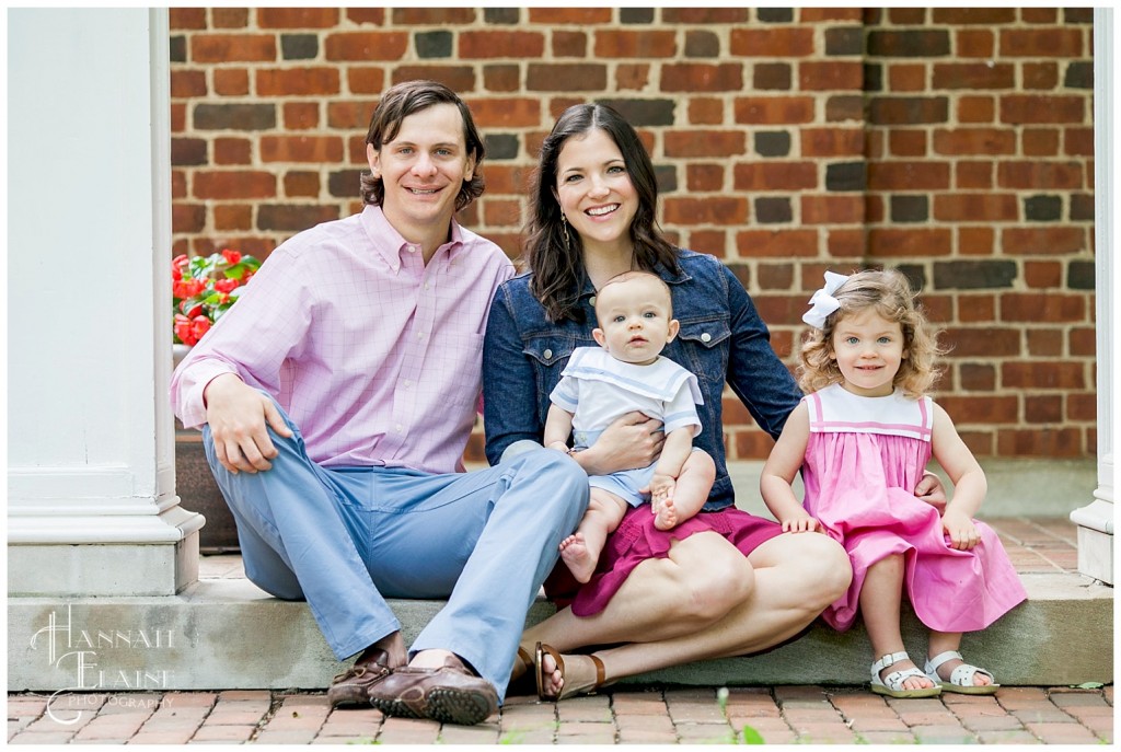 family of four sits for a family photo