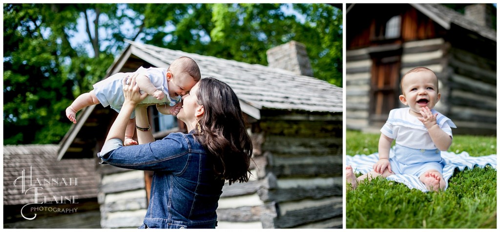 mom and baby take photos in front of rustic log cabins