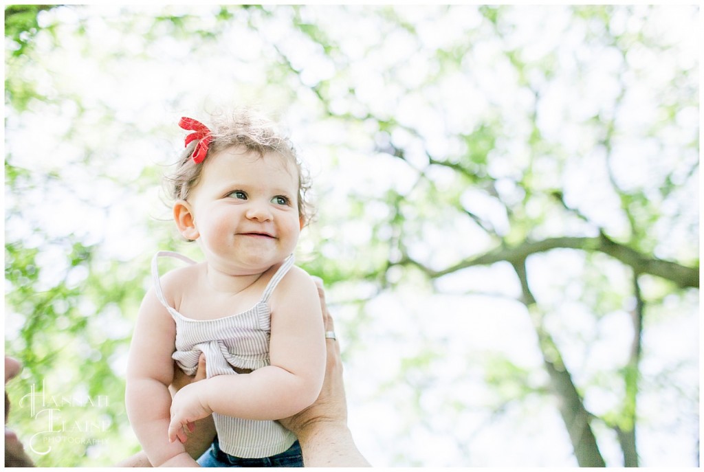 dad hoists little girl up into the air