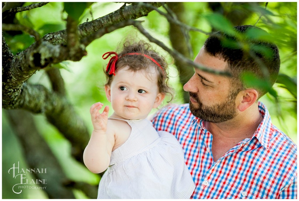 daddy and daughter investigate a tree at the park