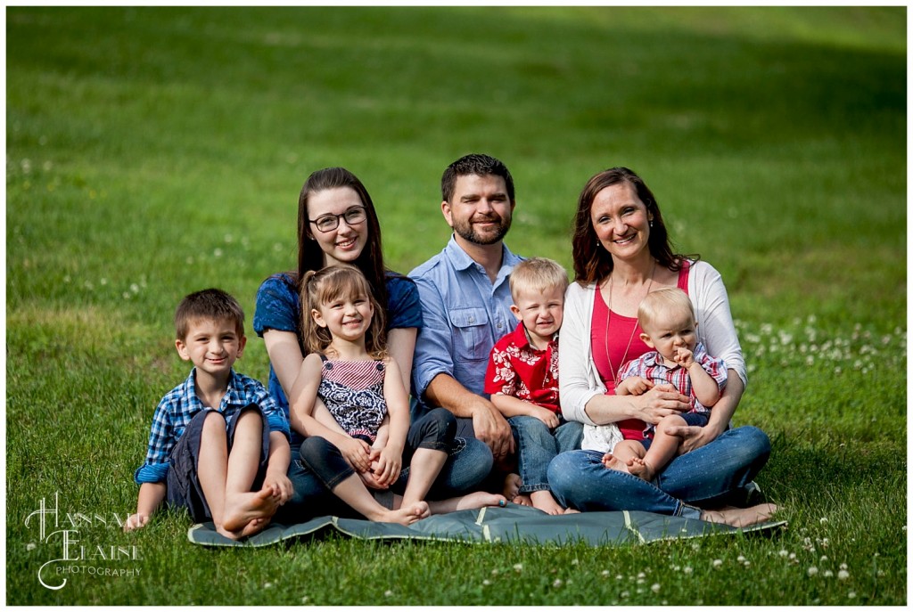 cute family of 7 sits on a blanket for a family photo