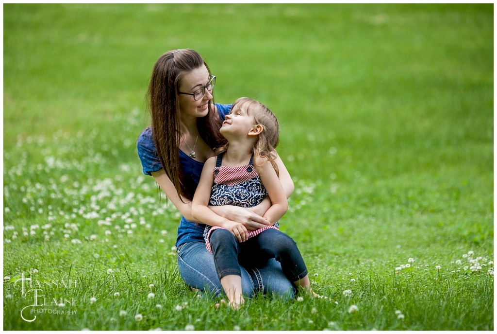 big sister holds little sister looking at each other