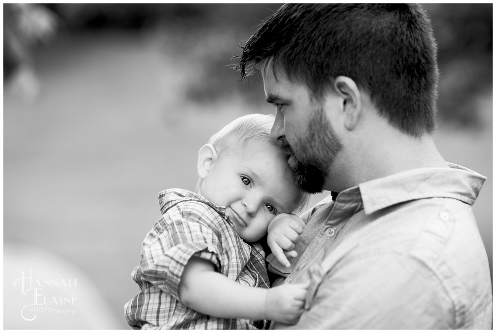 black and white image of dad cuddling toddler boy