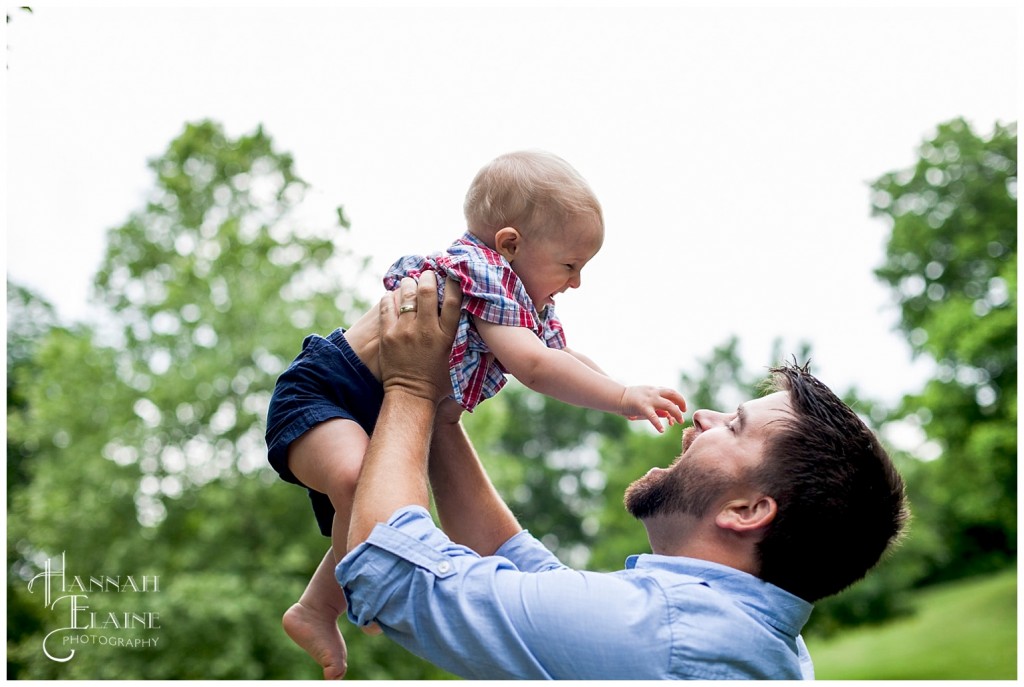 dad throws little boy up for a giggle