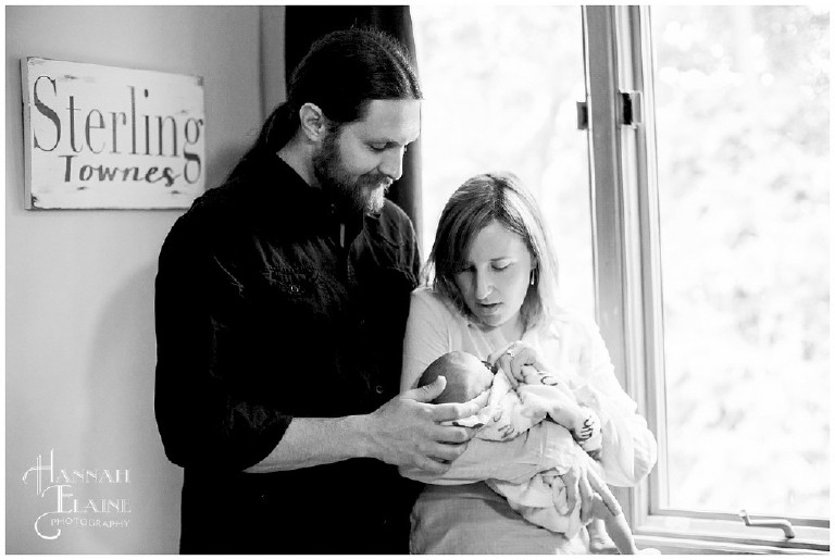 black and white image of couple holding newborn baby